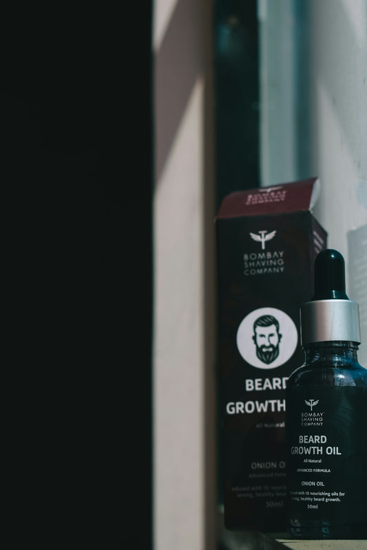 a bottle of beard growth oil next to a box
