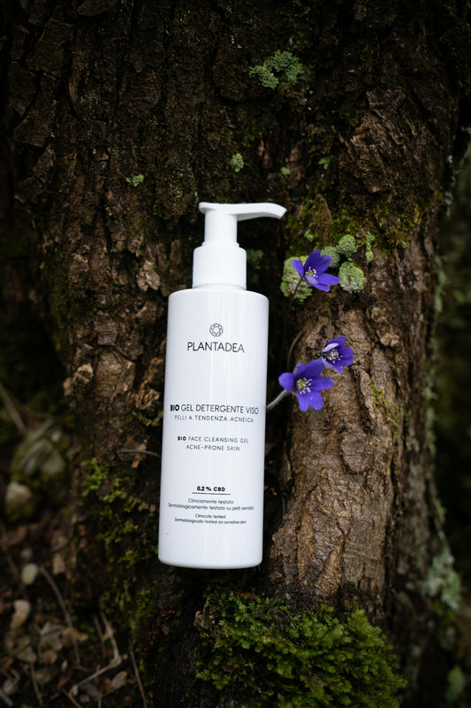 a close up of a bottle of lotion next to a tree