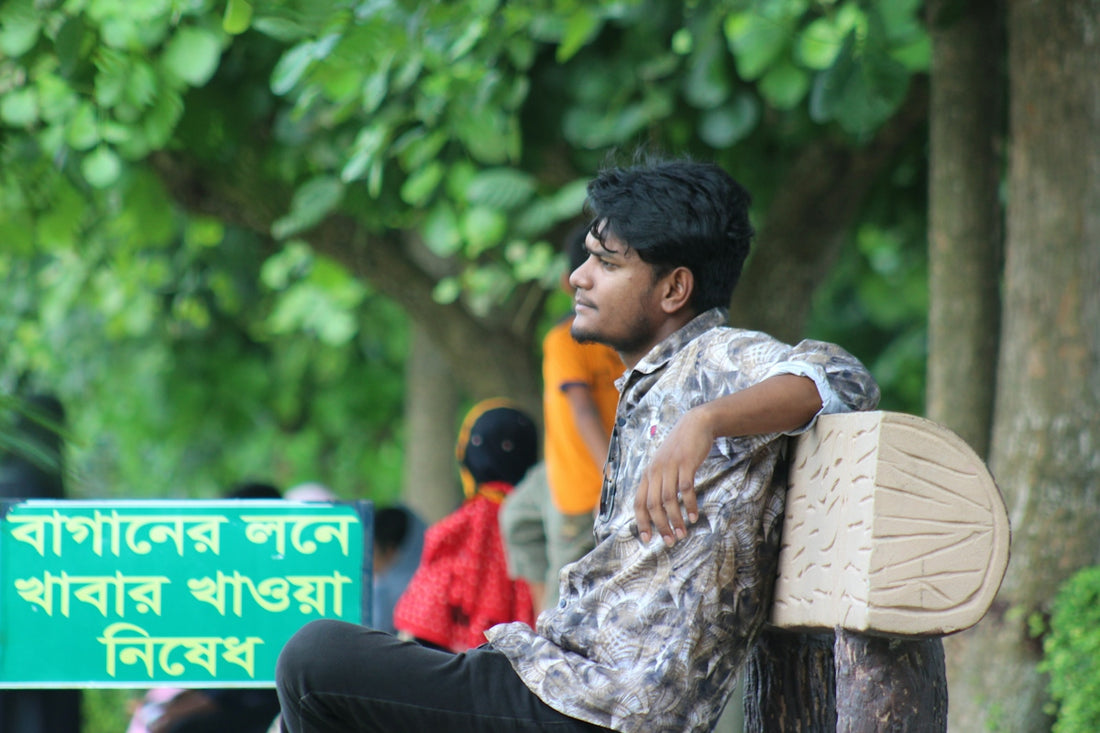 A man sitting on a bench in front of a sign