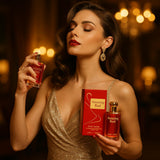 A lifestyle scene featuring a glamorous woman in an evening gown applying the Amazing Red perfume, with a blurred luxurious setting in the background, capturing a moment of elegance and confidence.